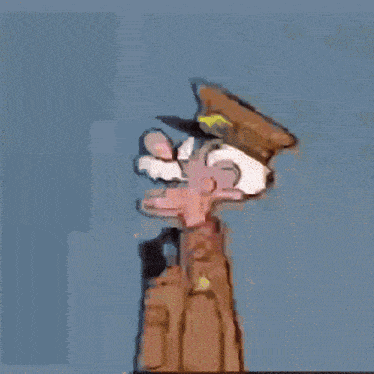 a figurine of a man wearing a hat and goggles is standing on a wooden table