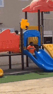 a child is playing on a slide at a playground .