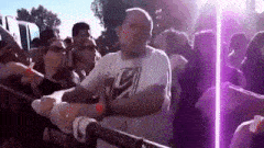 a man in a white shirt is dancing in front of a crowd of people .