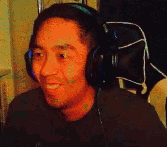 a man wearing headphones is sitting in a chair .