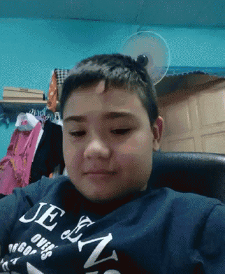 a young boy is wearing a jean shirt