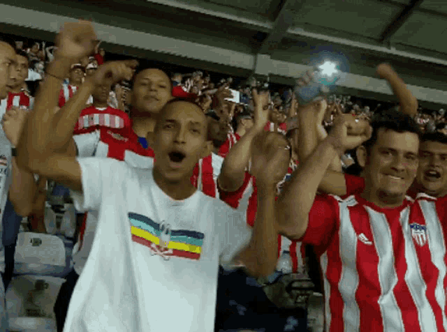 a group of people wearing red and white striped shirts with a united states of america logo on them