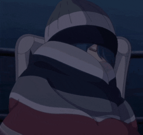 a person wrapped in a striped blanket with their face covered