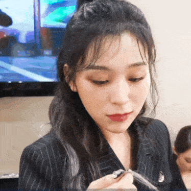 a woman in a striped jacket is holding a pen in her hand