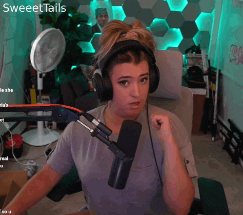 a woman wearing headphones is sitting in front of a microphone with the name sweettails on the bottom