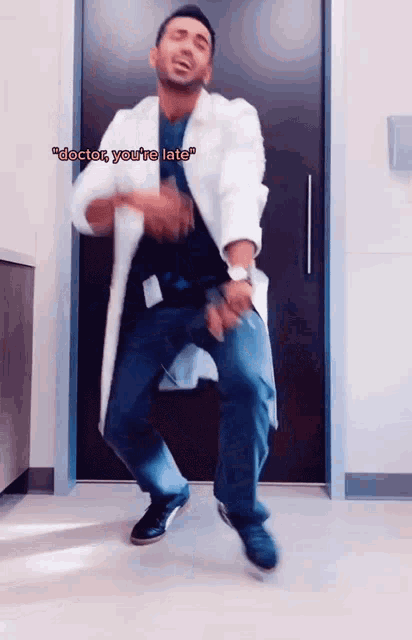 a man in a lab coat is dancing and says " doctor you 're late " on the bottom