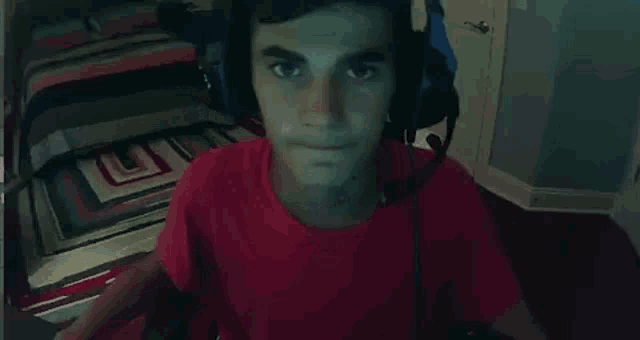 a person in a red shirt is standing on a rug in a bedroom