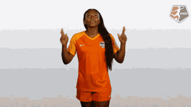 a female soccer player wearing an orange shirt with the word das on it