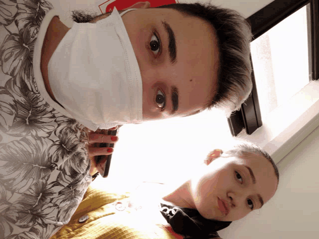 a man wearing a face mask talks on a cell phone