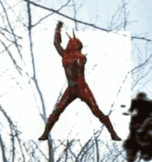 a man in a red costume is jumping in the air