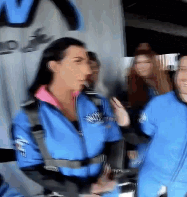 a blurry photo of a woman wearing a blue jacket that says nitro on it