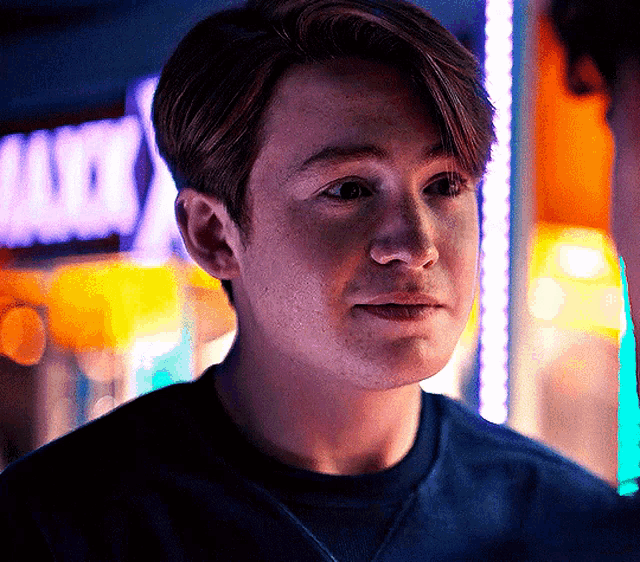 a close up of a man 's face with a sign in the background that says ' arcade '