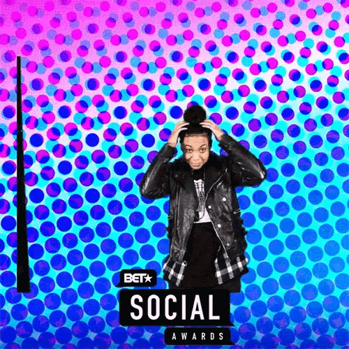 a woman in a leather jacket is standing in front of a bet social awards sign