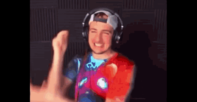 a man wearing headphones and a hat is dancing in a room .