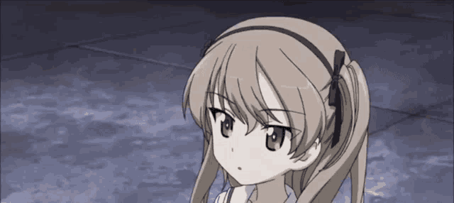 a girl with pigtails and a headband is looking at the camera .