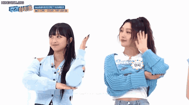 two girls are standing next to each other and one of them is wearing a blue sweater with a whale on it