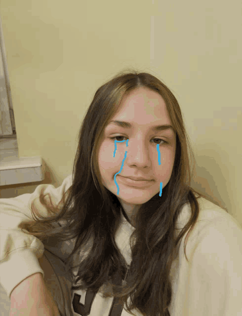 a girl with tears coming out of her eyes wearing a sweatshirt with the letter j on it