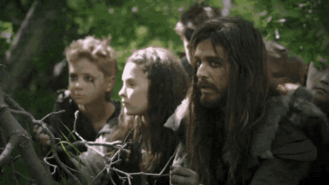a man with long hair is surrounded by children and says " i have a plan " at the bottom