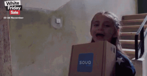 a girl holding a box that says souq.com on it