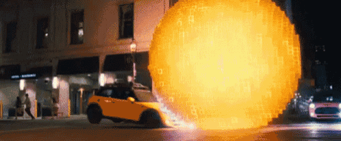 a yellow car is driving down a street with a huge explosion behind it