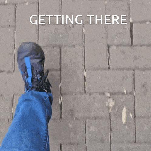 a person 's foot is walking on a brick sidewalk with the words " getting there " above it