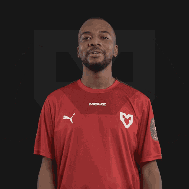 a man wearing a red shirt that says mouz on the front