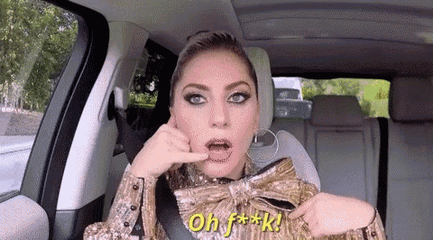lady gaga is sitting in the back seat of a car making a face .