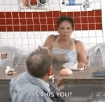 a man and a woman are sitting at a table in a restaurant and the woman is asking the man if he is this you .