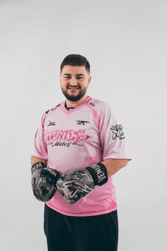 a man wearing boxing gloves and a pink shirt that says ' venus ' on it
