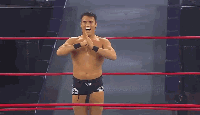 a man is bending over in a wrestling ring with his back to the camera