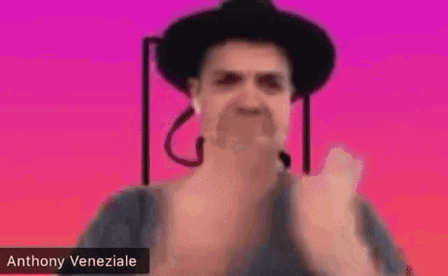 a man in a hat is giving the middle finger while talking on a video call .