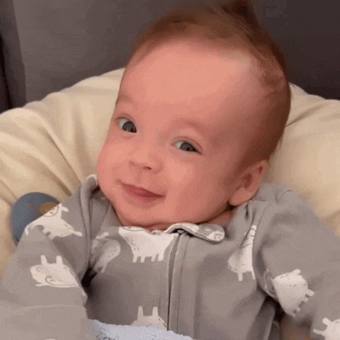 a baby wearing a sheep onesie is smiling