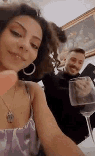 a man is holding a glass of wine next to a woman .