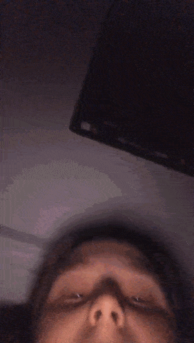 a close up of a person 's face with their eyes closed in a dark room