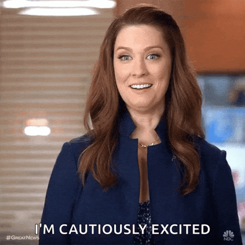 a woman is smiling and saying i 'm cautiously excited .