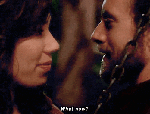 a man and a woman are looking at each other and the man is saying what now