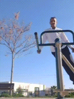 a man in a white shirt is riding a bike in a park