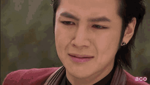 a close up of a man 's face with a tear running down his face .