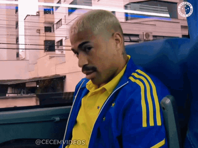 a man wearing a blue and yellow adidas jacket