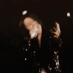 a man is singing into a microphone while wearing a black jacket .