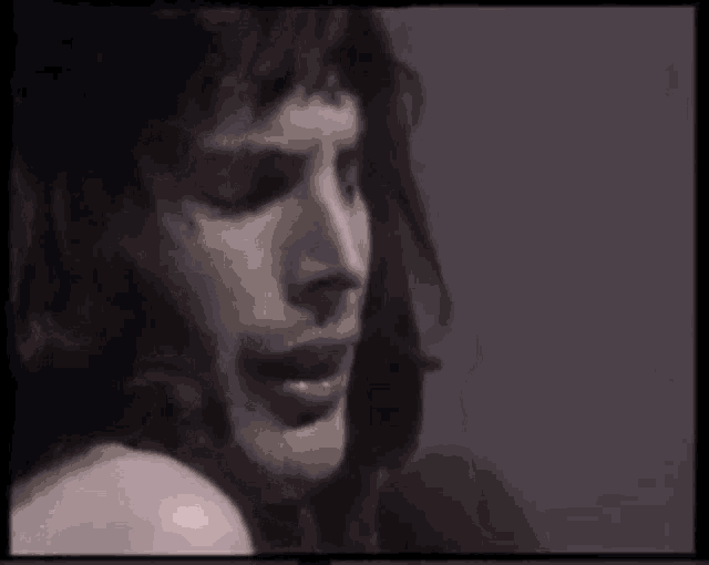 a man is singing into a microphone with a ring on his finger .