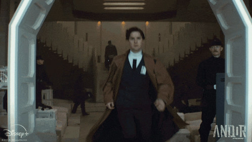 a man in a suit and tie is running through a doorway with disney + written on the bottom