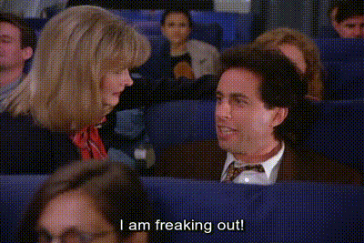 a man and a woman are sitting on a plane and the man is saying i am freaking out