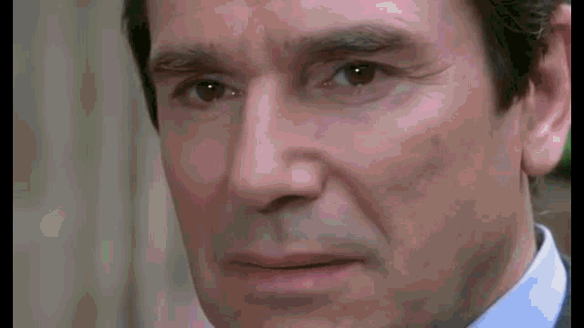 a close up of a man 's face with a slight smile on his face