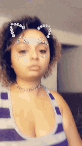 a woman with rhinestones on her face is wearing a cat ear headband .