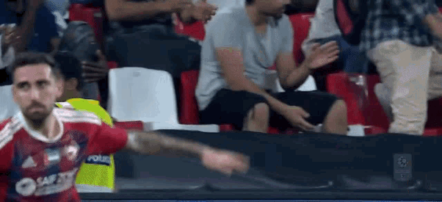 a soccer player wearing a red shirt that says ' santos ' on it