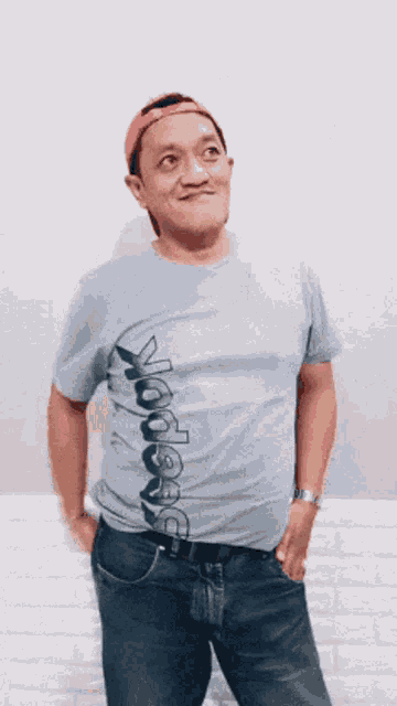 a man wearing a reebok t-shirt is holding something