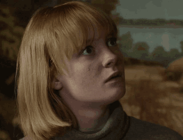 a close up of a woman 's face looking up at something