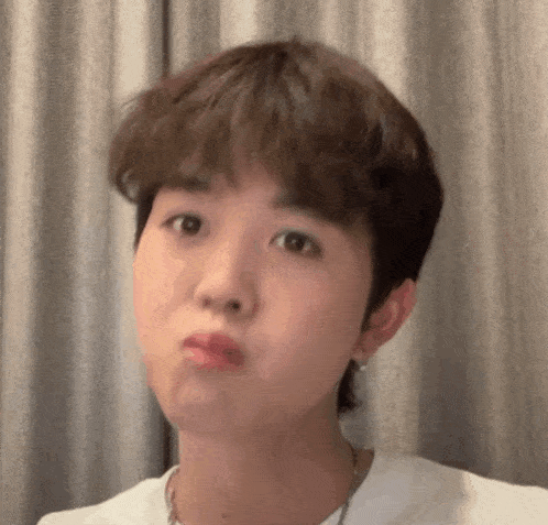 a close up of a young man making a funny face .