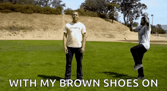 two men are standing on a grassy field with the words " with my brown shoes on " below them